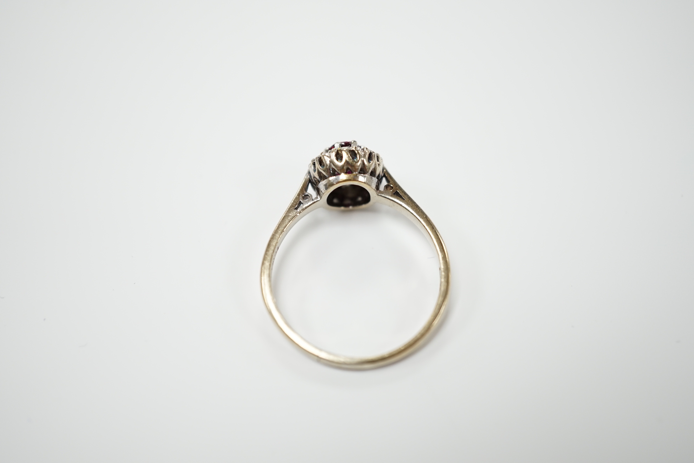 A 18ct white, ruby and diamond set oval cluster ring, size Q/R, gross weight 4.2 grams.
